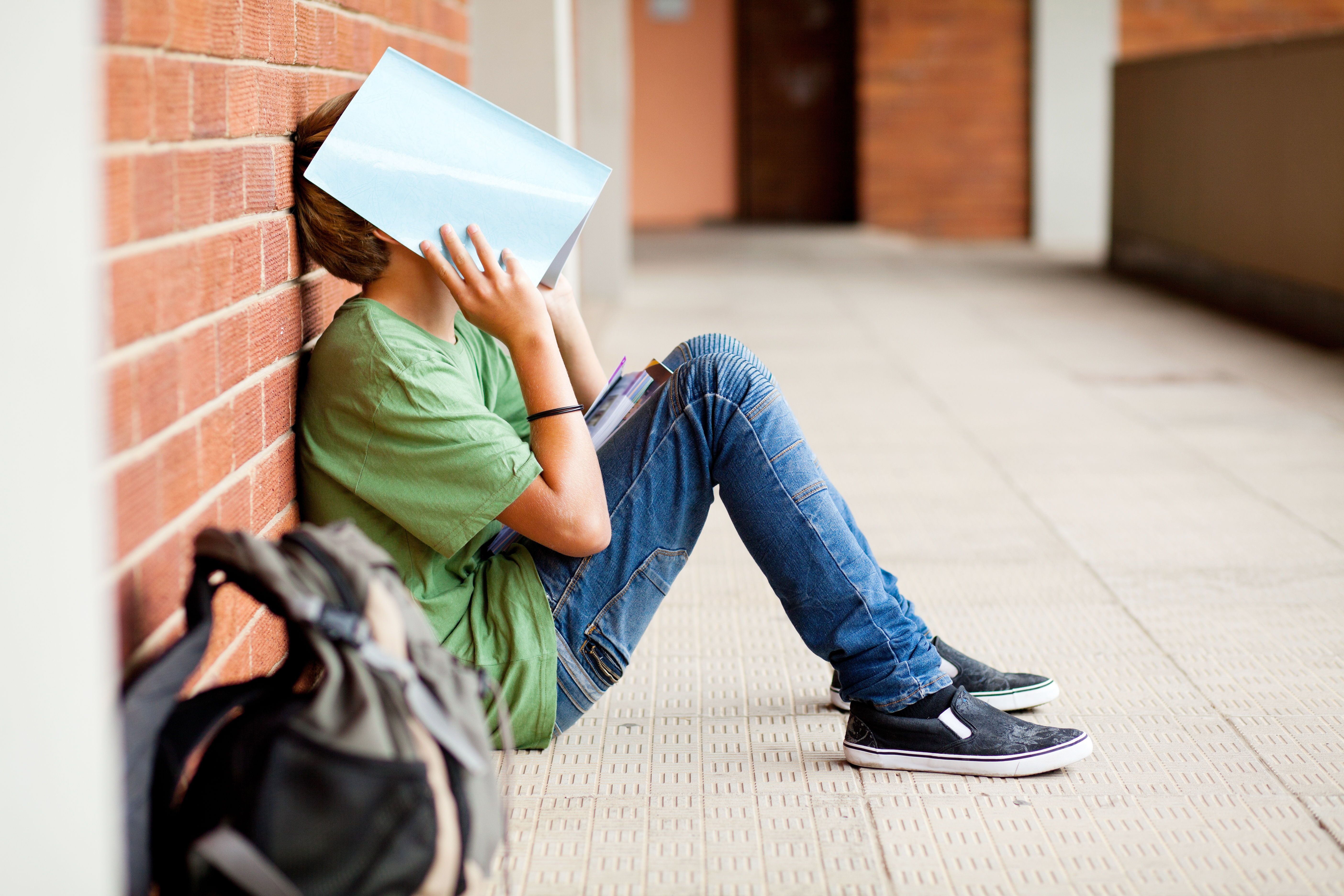 Student covers his face with book
