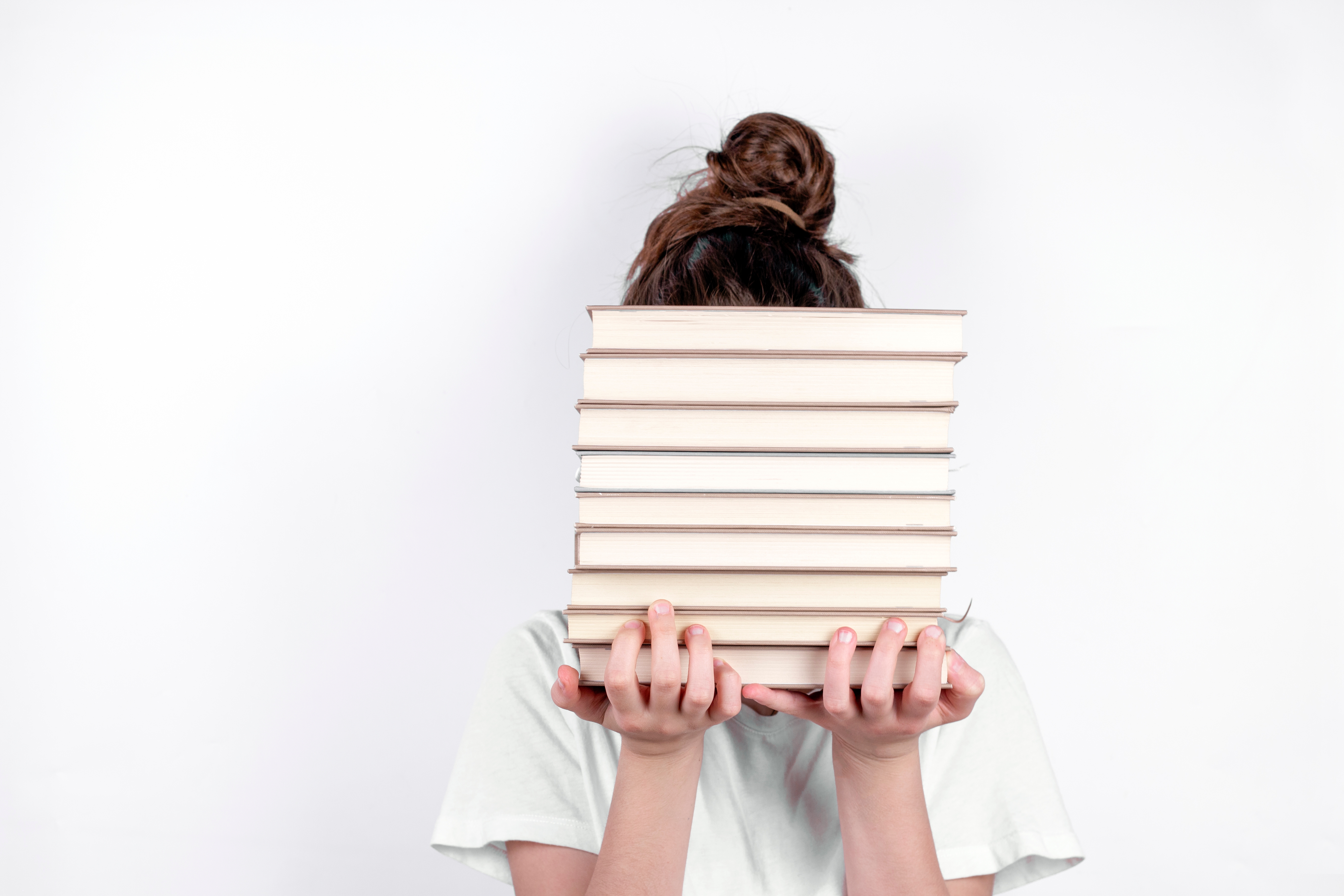 Student holds stack of books